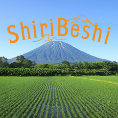 夏の羊蹄山と田んぼ。空にShiriBeshiの文字が浮かんでいる。