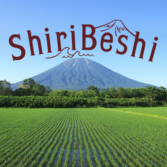 夏の羊蹄山と田んぼ。空にShiriBeshiの文字が浮かんでいる。